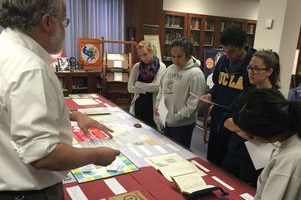 Students in a Fiat Lux class look at historicartifacts that promoted smoking and campaigned against it