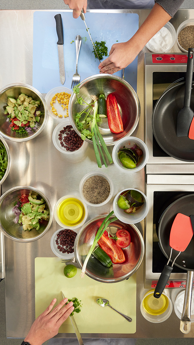 All ingredients in the Teaching Kitchen are measured and prepped before any class begins. Here, students learn the proper technique to chop cilantro to add to their guacamole.