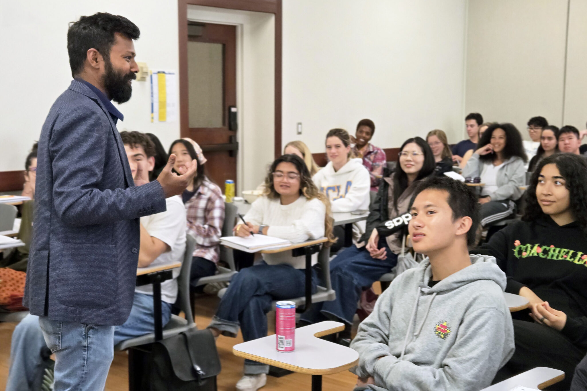 Professor Vetri Nathan, standing, with students seated and listening to his lecture.