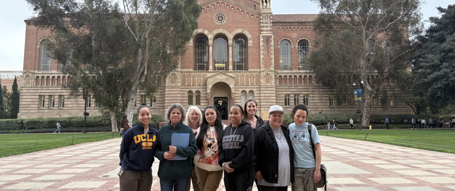 A group of students enrolled in front of Powell Library at UCLA. 